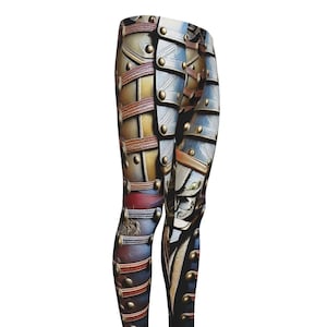 May include: Leggings with a detailed print resembling historical military armor. The design features a mix of metallic silver, gold, and brown tones, with red and blue accents. The leggings have a high-waisted design and a form-fitting silhouette.