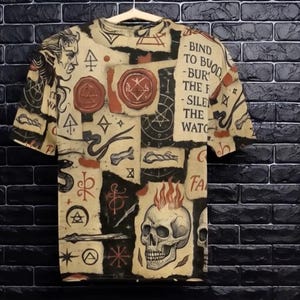 May include: A beige t-shirt with a black and red print of various symbols, including a skull with flames, snakes, and a pentagram. The text on the shirt reads "Bind to Blood", "Burn the Flesh", "Silence the Watchers", and "Fear".