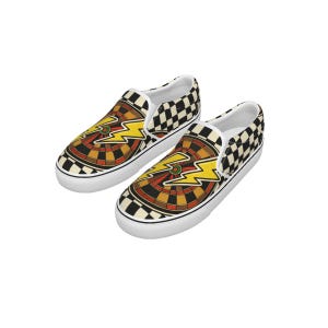 May include: Pair of slip-on sneakers featuring a dartboard design with a yellow lightning bolt graphic. The shoes have a black and white checkered pattern on the heel and sides, with a white sole.