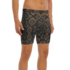Pode incluir: Calções boxer com padrão de pele de cobra em tons de castanho e preto. Os calções são justos e chegam a meio da coxa. O tecido tem um aspeto texturizado, imitando as escamas de uma cobra. O design é arrojado e apelativo.