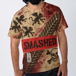 May include: A short-sleeved t-shirt with a distressed design featuring winged monkey illustrations, tire tracks, and a skull and crossbones. The word "SMASHED" is printed in large, black letters on a red band across the shirt.