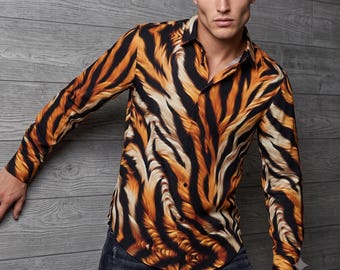 Pode incluir: Uma camisa de manga comprida com botões, apresentando um padrão arrojado de riscas de tigre em tons de laranja, preto e branco. A camisa tem um colarinho clássico, uma carcela de botões frontal completa e mangas compridas com punhos abotoados.