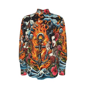 Puede incluir: Una camisa de manga larga con botones y un estampado colorido que presenta llamas, un ancla y dos mujeres con tatuajes. El estampado recuerda al arte tradicional del tatuaje japonés.
