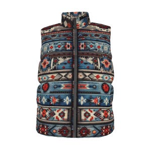 Op de afbeelding: Een mouwloos gewatteerd vest met een kleurrijk geometrisch patroon in tinten blauw, rood en crème. Het vest heeft een hoge kraag en een lange ritssluiting. Het ontwerp bevat herhaalde, op stammen geïnspireerde motieven.