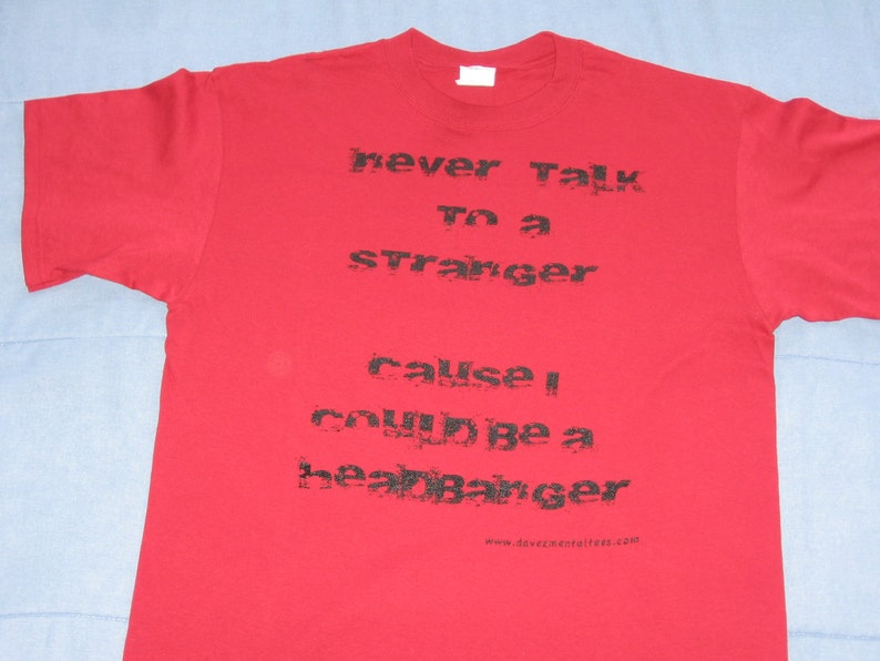 May include: Red t-shirt with black text that reads "never talk to a stranger cause I could be a heartbreaker" and a website address at the bottom.