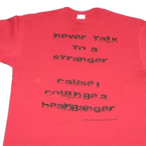 May include: Red t-shirt with black text that reads "never talk to a stranger cause I could be a heart banger" and a website address at the bottom.