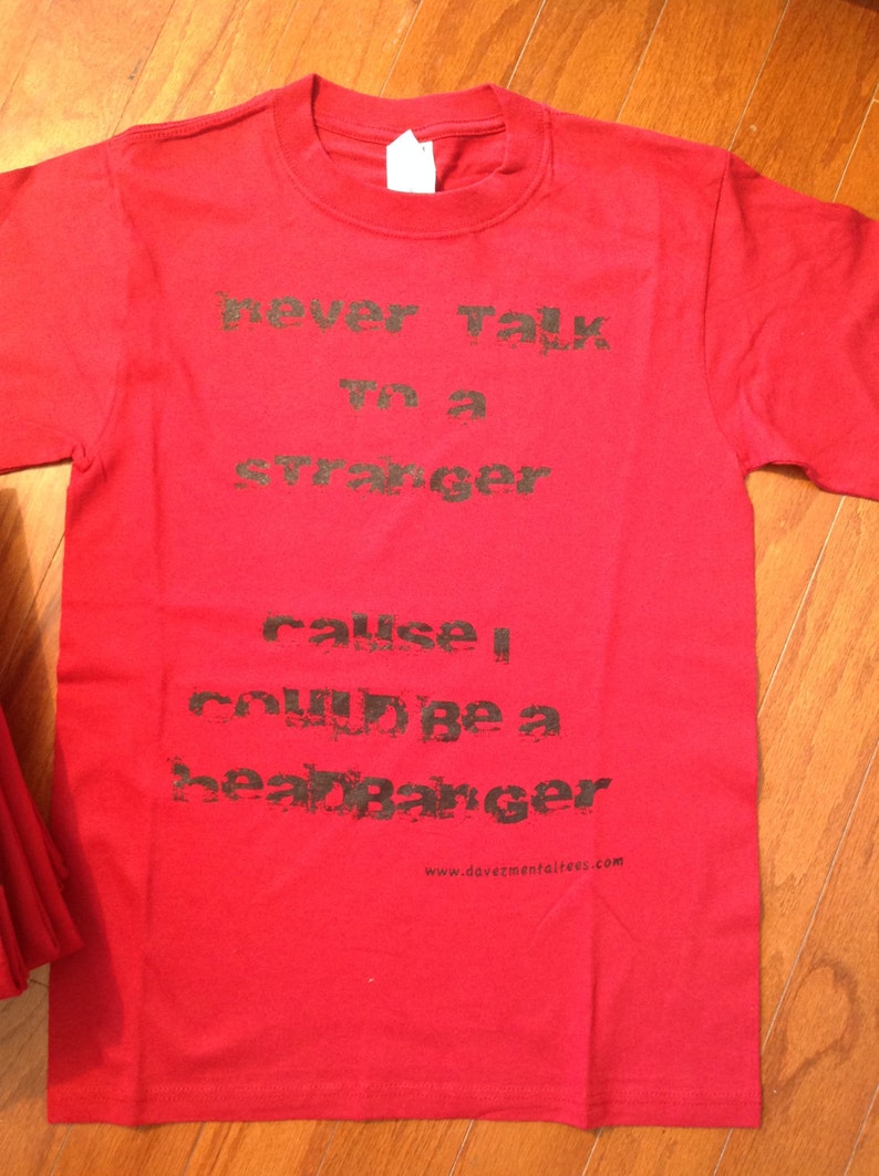 May include: Red t-shirt with black text that reads "never talk to a stranger cause I could be a heartbreaker" and a website address at the bottom.