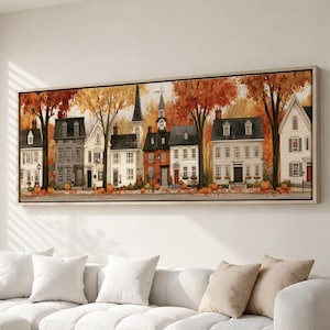 May include: A panoramic wall art print featuring a row of multi-story houses in an autumn setting. The scene includes orange and yellow trees, fallen leaves, and pumpkins scattered along the sidewalk in front of the buildings with varied facades.