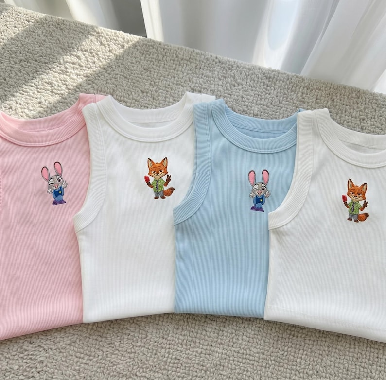 May include: Four ribbed tank tops in light pink, white, light blue, and white. Each tank top features a small embroidered character graphic on the chest. The pink and light blue tanks display a rabbit character, while the white tanks show a fox.