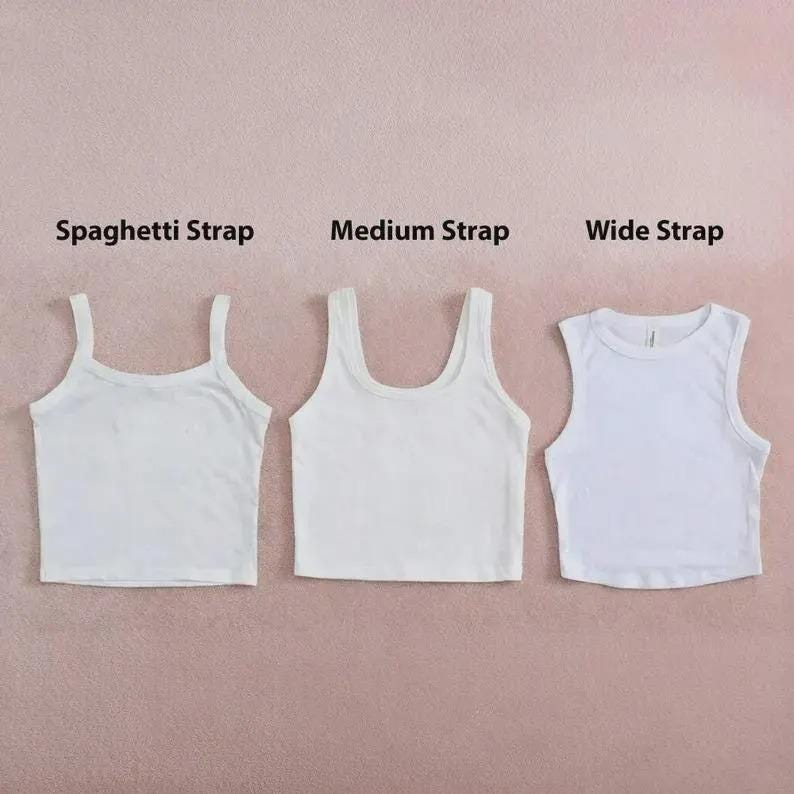 May include: Three white crop tops arranged side by side. The first is labeled Spaghetti Strap, the second is labeled Medium Strap, and the third is labeled Wide Strap. Each top features a different shoulder strap width and a scoop neckline.