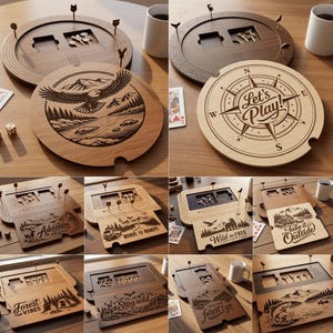 May include: A collection of wooden game boards featuring various laser-engraved designs including an eagle, a compass with the text Let's Play, and nature scenes with phrases like Adventure Awaits, Born to Roam, Wild and Free, and Forest Vibes.