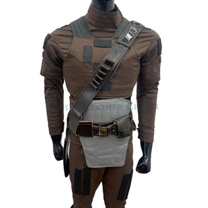 May include: A brown tactical costume set featuring a long-sleeved shirt, trousers, and a chest plate. It includes a dark brown shoulder strap with ammunition loops, a belt with attached pouches, and a light grey abdominal guard with panel detailing.
