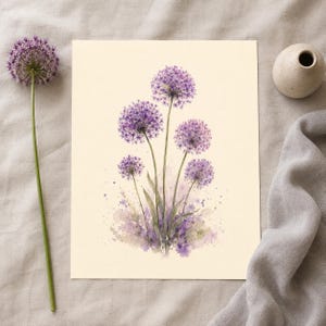 May include: A rectangular art print featuring a watercolor illustration of five purple allium flowers with green stems and leaves on a cream background. The painting includes soft purple paint splatters at the base of the floral arrangement.