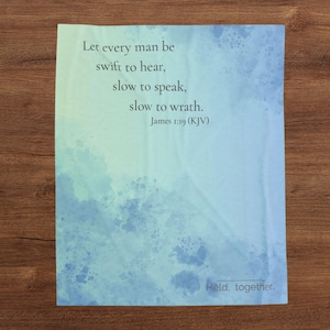 May include: A rectangular blanket featuring a watercolour-style blue and green gradient background. The text reads: Let every man be swift to hear, slow to speak, slow to wrath. James 1:19 (KJV). The words Held. together. appear in the bottom right corner.