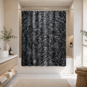 May include: A shower curtain featuring a dark, abstract pattern with deep black and charcoal grey tones that mimic the appearance of crinkled foil or textured metallic surfaces, suspended from a silver rod with integrated metal rings.