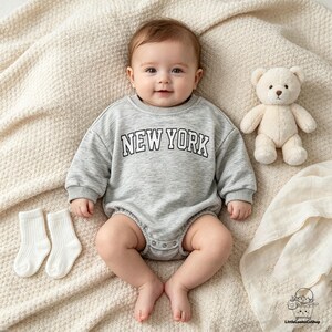 Body infantil com estampa de letras "NOVA YORK", mangas compridas e modelagem balonê, estilo vintage, ideal para chá de bebê.