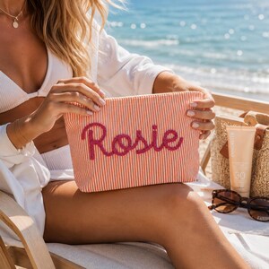 Nécessaire de maquiagem personalizada com nome, listrada, em chenille e tecido seersucker, com pingente de margarida. Bolsa de cosméticos personalizada com zíper. Presente de aniversário para ela.