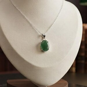 l Emerald Gemstone Necklace featuring a 10–15Ct oval-cut green emerald pendant suspended from a delicate silver-tone chain. The simple and elegant silhouette creates a timeless jewelry style that can transition easily from daytime to evening wear. Designed as May birthstone jewelry, this emerald pendant is suitable for birthdays, anniversaries, weddings, parties, dinners, office outfits, vacations, and everyday accessorizing for women who love classic gemstone jewelry.