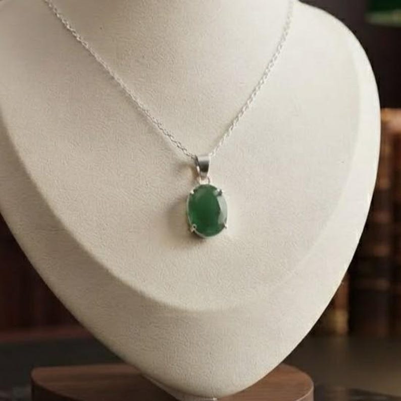 l Emerald Gemstone Necklace featuring a 10–15Ct oval-cut green emerald pendant suspended from a delicate silver-tone chain. The simple and elegant silhouette creates a timeless jewelry style that can transition easily from daytime to evening wear. Designed as May birthstone jewelry, this emerald pendant is suitable for birthdays, anniversaries, weddings, parties, dinners, office outfits, vacations, and everyday accessorizing for women who love classic gemstone jewelry.