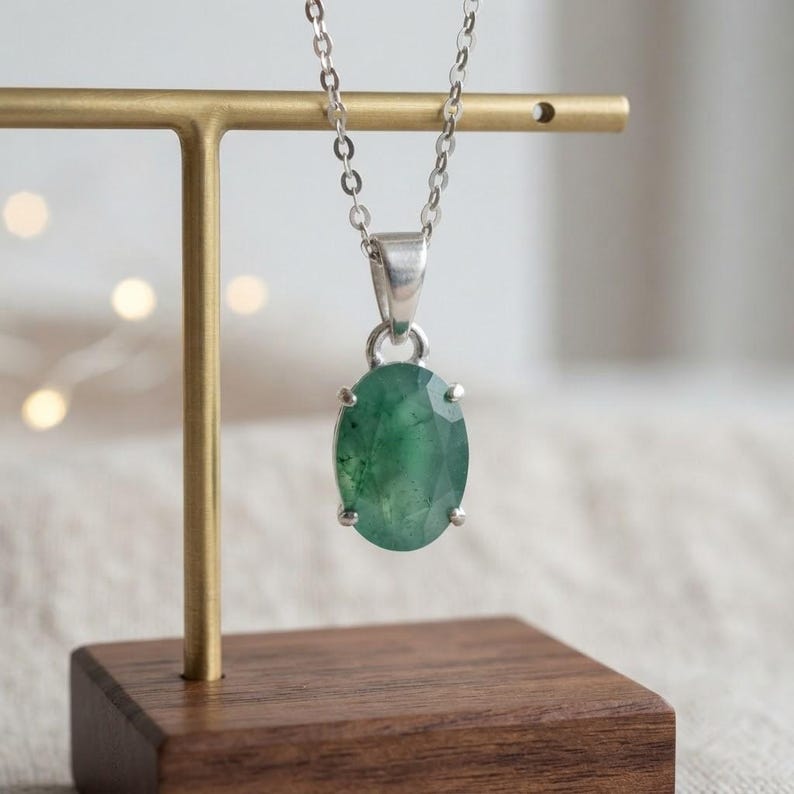 Natural Emerald Gemstone Necklace featuring a 10–15Ct oval-cut green emerald pendant suspended from a delicate silver-tone chain. The simple and elegant silhouette creates a timeless jewelry style that can transition easily from daytime to evening wear. Designed as May birthstone jewelry, this emerald pendant is suitable for birthdays, anniversaries, weddings, parties, dinners, office outfits, vacations, and everyday accessorizing for women who love classic gemstone jewelry.