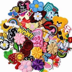 May include: A large collection of colorful embroidered iron-on patches featuring various designs including flowers, a rainbow, a unicorn, a yellow bear face, a frog, fruits, a sun with sunglasses, and text elements like I MY DOG and WOW.