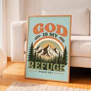 Puede incluir: Una lámina decorativa rectangular con fondo azul claro y el texto en naranja GOD IS MY REFUGE y PSALM 46:1. El diseño incluye un arcoíris naranja estilizado sobre una cordillera con pinos verdes en la parte inferior de la imagen.