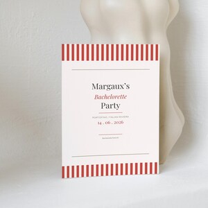Peut inclure: Une carte d'invitation rectangulaire avec des rayures verticales rouges et blanches sur les bords supérieur et inférieur. Le texte central indique Margaux's Bachelorette Party, Portofino, Italian Riviera, 14.06.2026, et Bachelorette Party Kit.