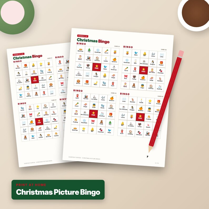 Puede incluir: Dos hojas de papel blanco con juegos de bingo navide&ntilde;o que presentan iconos festivos coloridos en formato de cuadr&iacute;cula. Cada tarjeta incluye un cuadrado rojo central etiquetado como FREE. Un l&aacute;piz rojo se encuentra en diagonal sobre la hoja derecha.