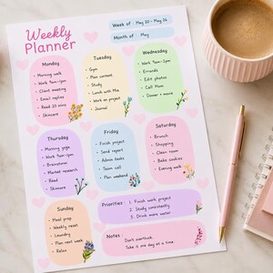 Op de afbeelding: Een weekplanner-vel met pastelkleurige dagelijkse secties, bloemaccenten en hartjesmotieven. De tekst bevat 'Weekly Planner', 'Week of: May 20-May 26', 'Month of: May', 'Priorities' en 'Notes'. Een roze memoblaadje bevat de tekst 'You Got This!'