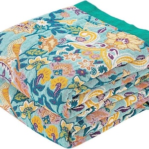 May include: A folded woven throw blanket featuring a vibrant floral pattern in shades of teal, mustard yellow, and purple. The fabric displays intricate botanical motifs including stylized flowers and leaves, finished with a solid teal border.