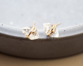 May include: A pair of gold wire wrapped clear quartz crystal earrings.