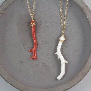 Puede incluir: Dos delicados collares con cadenas de oro y colgantes de rama de coral natural. Un colgante es de coral rojo, el otro es de coral blanco.