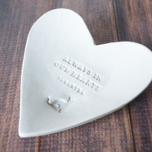 White ceramic heart-shaped dish with the inscription "Always in our hearts" and personalized with the pet's name