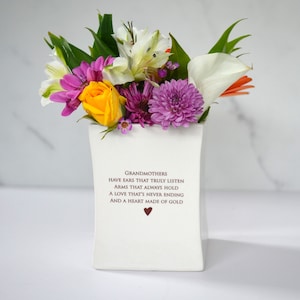 This sweet ceramic flower vase would be a perfect Christmas gift for your grandmother, grandma, or nana. It has this text on it: Grandmothers have ears that truly listen, arms that always hold, a love that's never ending and a heart made of gold.