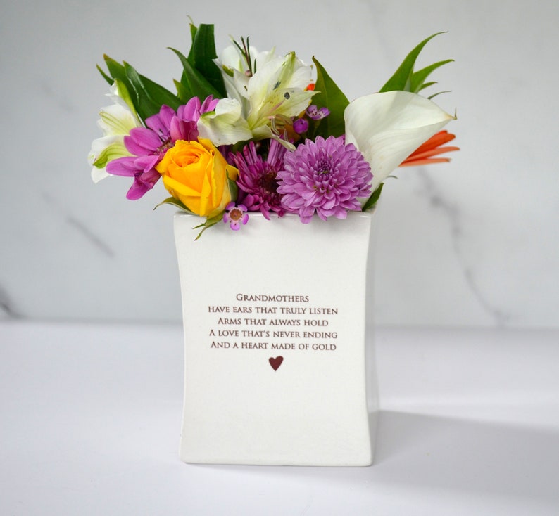 This sweet ceramic flower vase would be a perfect Christmas gift for your grandmother, grandma, or nana. It has this text on it: Grandmothers have ears that truly listen, arms that always hold, a love that's never ending and a heart made of gold.