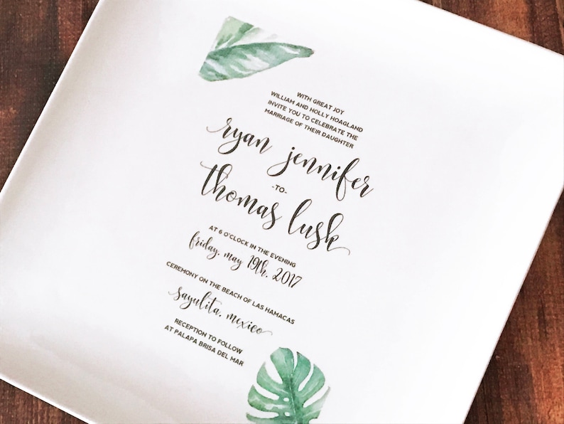 May include: Wedding invitation with a tropical theme. The invitation features a green watercolor leaf design and the text "With great joy William and Holly Hoagland invite you to celebrate the marriage of their daughter Ryan Jennifer to Thomas Lusk at 6 o'clock in the evening Friday, May 19th, 2017 Ceremony on the beach of Las Hamacas Sayulita, Mexico Reception to follow at Palapa Brisa del Mar"