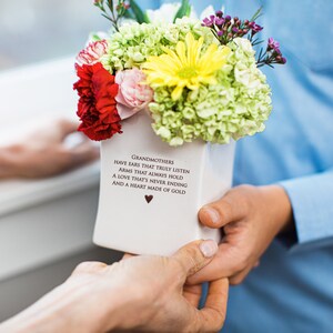 This sweet ceramic flower vase would be a perfect Christmas gift for your grandmother, grandma, or nana. It has this text on it: Grandmothers have ears that truly listen, arms that always hold, a love that's never ending and a heart made of gold.