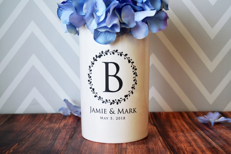 White ceramic vase with a black wreath design and the letter 'B' in the center. The vase also has the text 'Jamie & Mark' and 'May 5, 2018' printed on it.