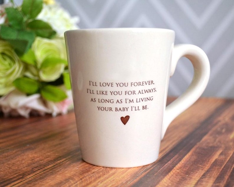 This sweet ceramic mug would be a perfect Mothers Day or birthday gift. It's made of earthenware clay and has this text printed on it: I'll Love You Forever, I'll Like You for Always, As Long as I'm Living Your Baby I'll Be.