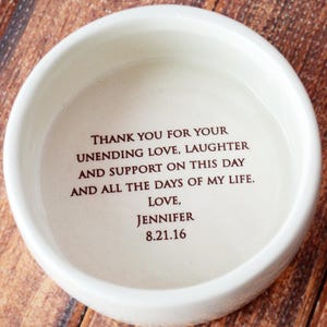 May include: White ceramic bowl with a brown inscription that reads "Thank you for your unending love, laughter and support on this day and all the days of my life. Love, Jennifer 8.21.16"