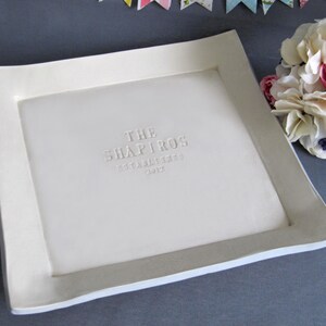 White ceramic serving tray with a raised border and the text "THE SHAPIROS ESTABLISHED 2012" embossed in the center.