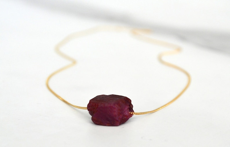 This natural raw Ruby necklace is a perfect gift for a July birthday. Ruby represents love, energy, passion, power, and a zest for life. Each is unique in shape and size. Colors range from vibrant red to purplish red.