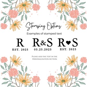 May include: A floral design with yellow and pink flowers surrounds the text "Stamping Options" with examples of stamped text: "R EST. 2025", "R&S 05.25.2025", and "R&hearts;S EST. 2025". The text "PLEASE ADD THE TEXT IN THE PERSONALIZATION SECTION." is below the examples.