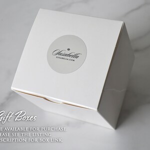 May include: A white square gift box with a round sticker featuring the text "Susabella" and "SUSABELLA.COM". The box is on a white marble surface. Text on the image reads "Gift Boxes ARE AVAILABLE FOR PURCHASE. PLEASE SEE THE LISTING DESCRIPTION FOR BOX LINK."