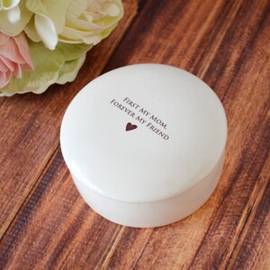 K&ouml;nnte beinhalten: Wei&szlig;e Keramik-Schmuckschatulle mit dem Text "First my mom, forever my friend" und einem kleinen roten Herzen.