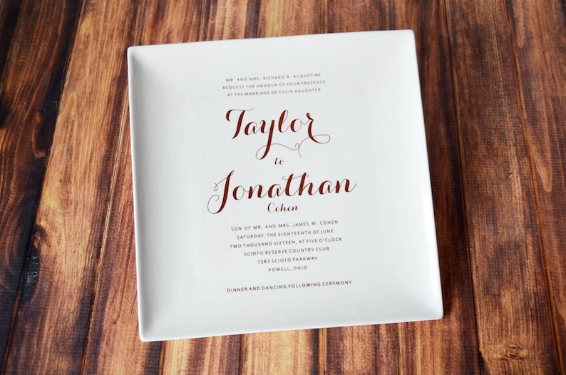 May include: A white ceramic plate with a wedding announcement for Taylor and Jonathan Cohen. The announcement includes the date, time, and location of the wedding ceremony. The text is printed in black and red.