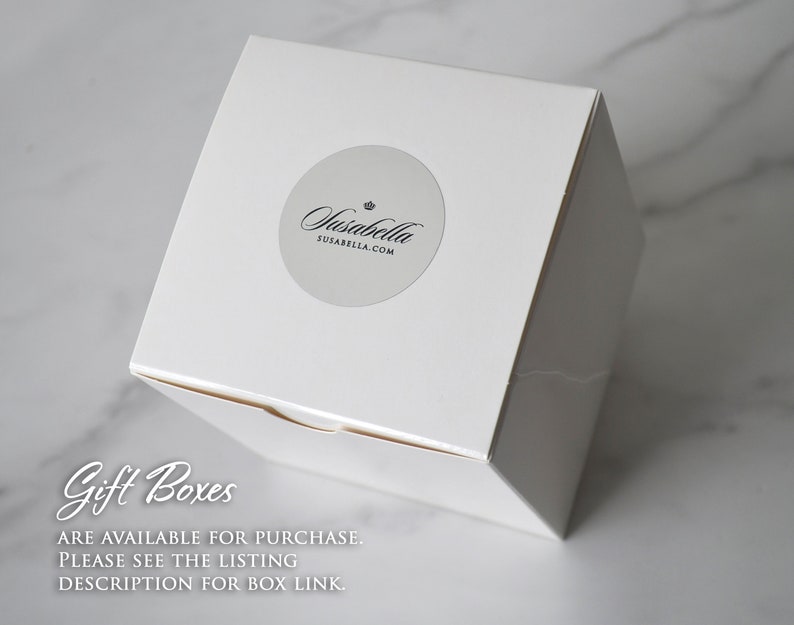 Op de afbeelding: Witte cadeaudoos met een zilveren sticker waarop "Jasabella" en "susabella.com" staat. De tekst "Gift Boxes" is in zwarte cursieve letters op de doos geschreven. De tekst "ARE AVAILABLE FOR PURCHASE. PLEASE SEE THE LISTING DESCRIPTION FOR BOX LINK." is in zwart onder de tekst "Gift Boxes" geschreven.