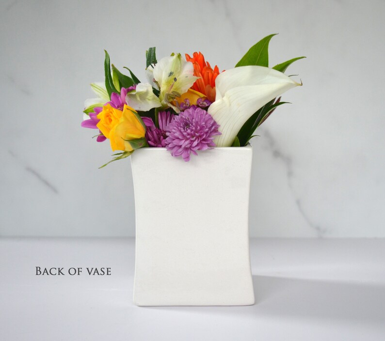 This sweet ceramic flower vase would be a perfect Christmas gift for your grandmother, grandma, or nana. It has this text on it: Grandmothers have ears that truly listen, arms that always hold, a love that's never ending and a heart made of gold.