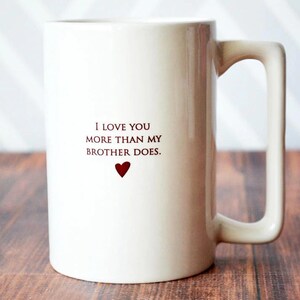 White ceramic mug with a heart and the text "I love you more than my brother does."