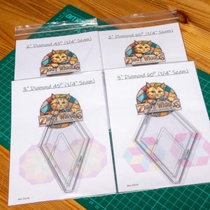 May include: Four clear acrylic quilting templates in plastic sleeves, labelled 2" Diamond 45° (1/4" Seam), 2" Diamond 60° (1/4" Seam), 3" Diamond 45° (1/4" Seam), and 3" Diamond 60° (1/4" Seam), each featuring a Ziggy Wiggles cat logo.